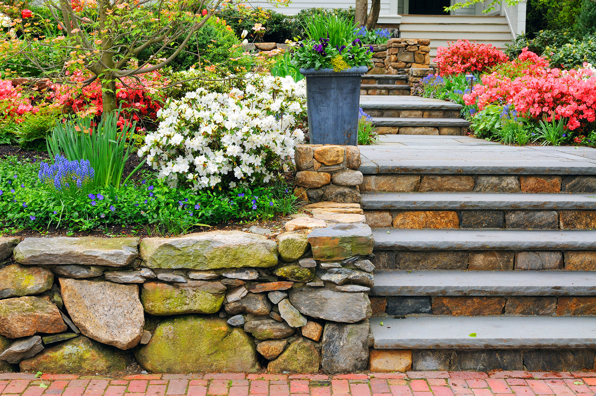 Stone retaining wall with steps and colorful flower garden