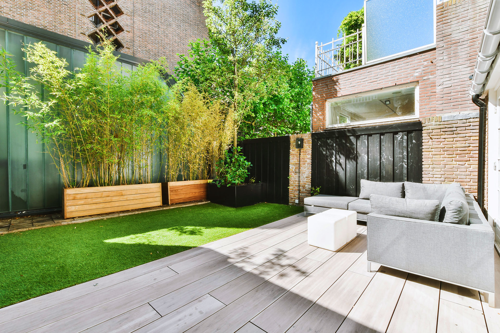 Modern backyard patio with artificial turf and seating